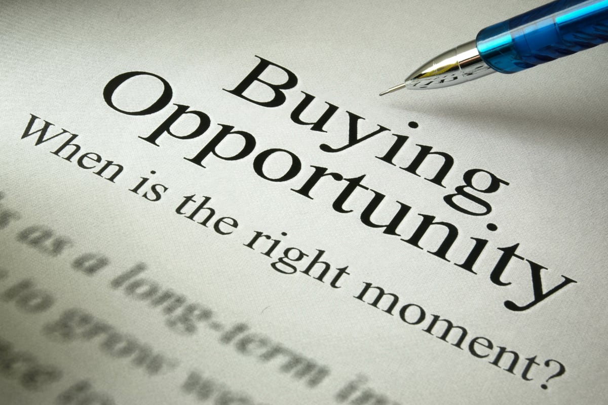 A pen pointing to the text Buying Opportunity on a piece of paper