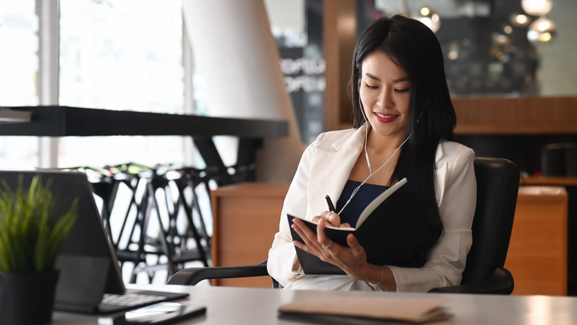 woman sitting at a desk and writing in a book