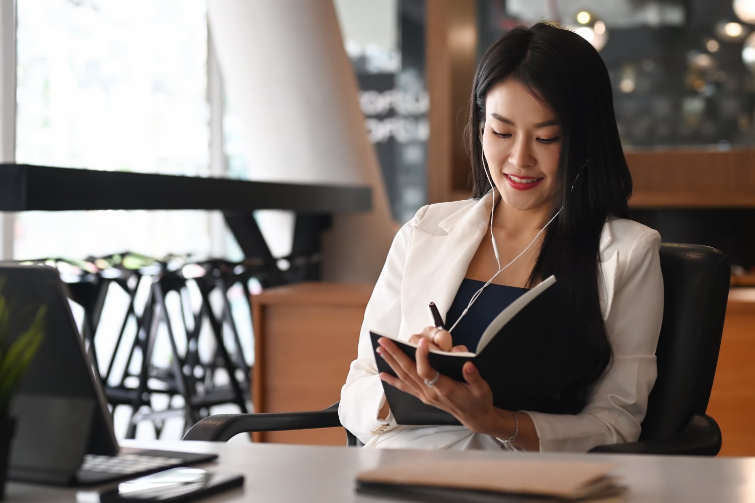 woman sitting at a desk and writing in a book