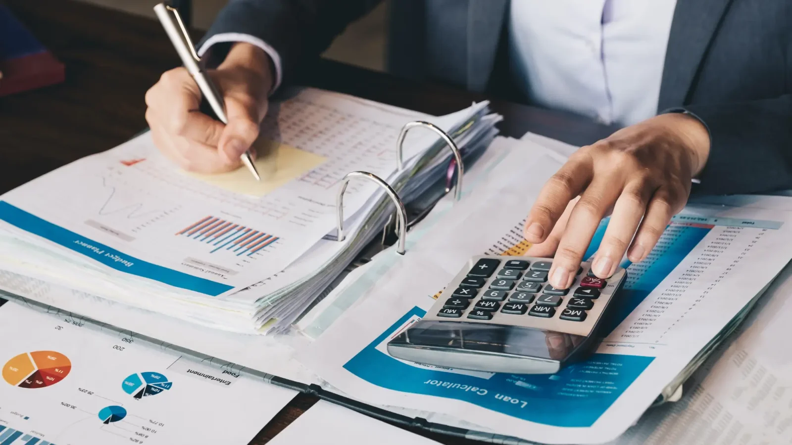 A person using a calculator to help plan business taxes
